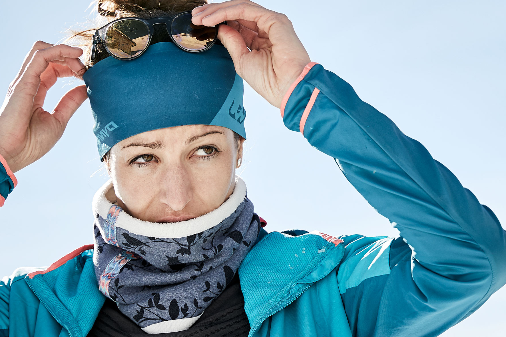 Portrait of Roxy at the top of the mountain in her sport apparel, about to put on her sunglasses.