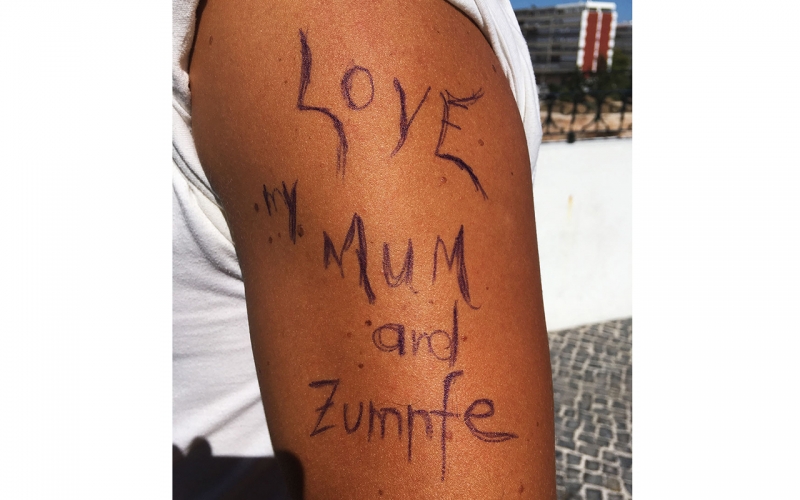 Jessica Zumpfe Photography's assistant's strong, tanned arm, with a tattoo that he loves his mom and Zumpfe.