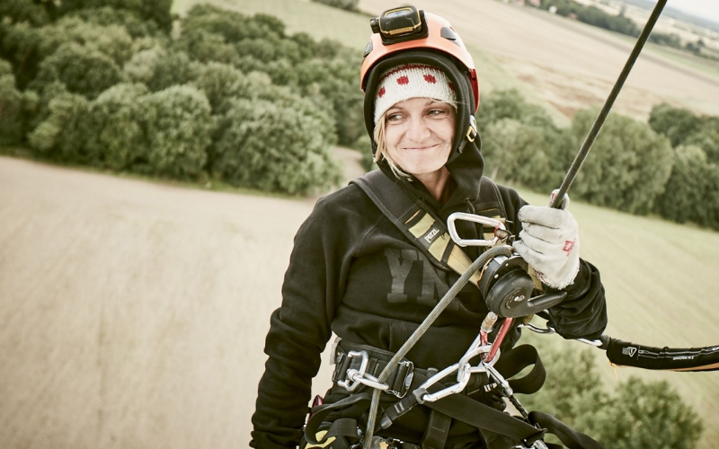 When you hire a photographer, you don't always expect them to abseil down a wind turbine. This is a photo of Jessica Zumpfe Photography at work - hanging in the ropes off a wind turbine while shooting