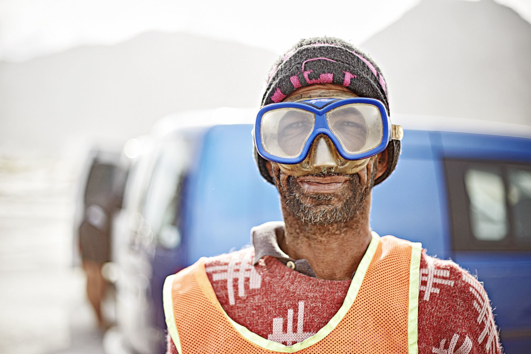 Portrait of David, the car guard at muizenberg kite sport sporting his underwater goggles, protecting him from the sand blasting.