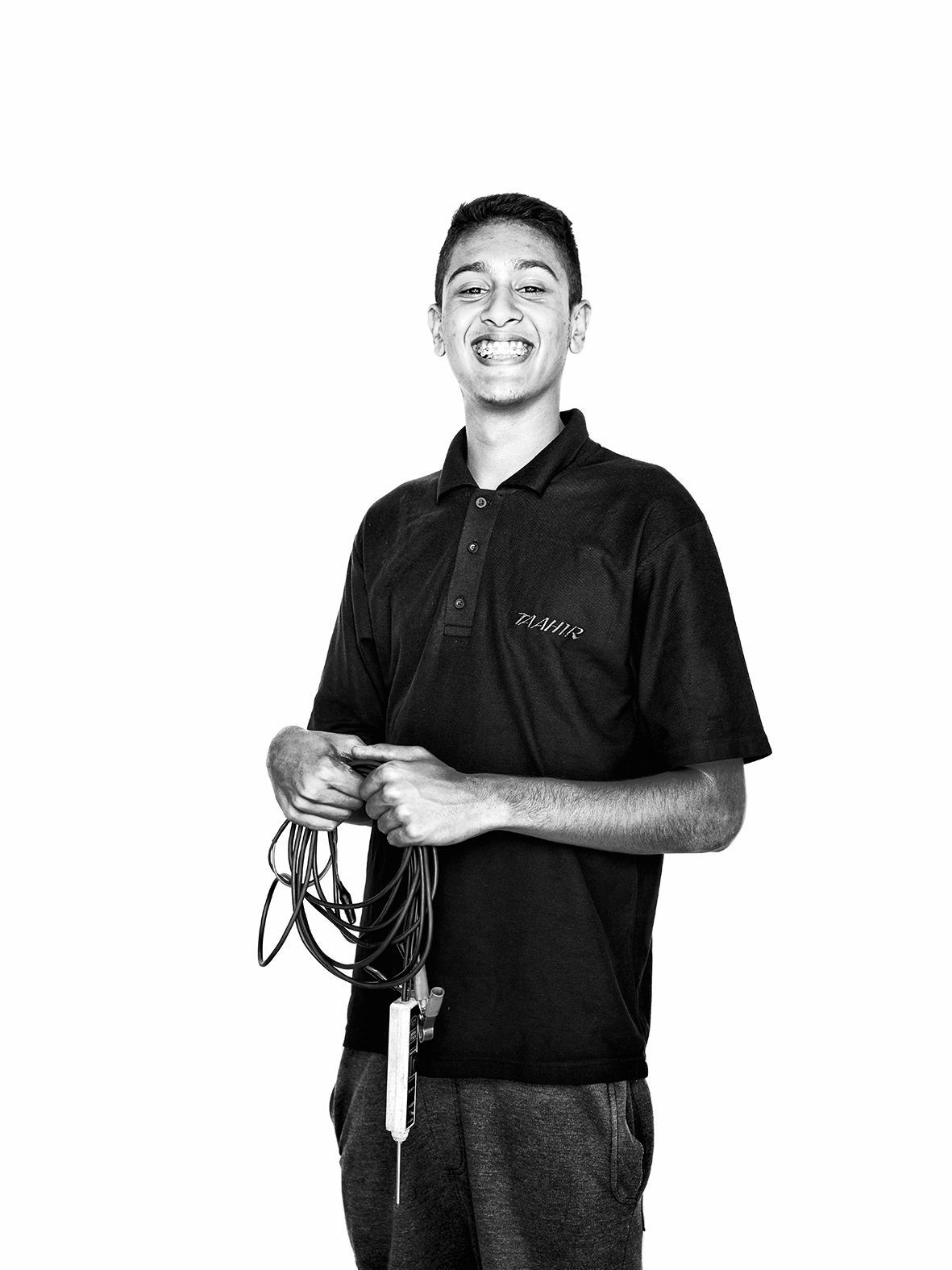 Young mechanic proudly holding a gadget in Cape Town, South Africa.