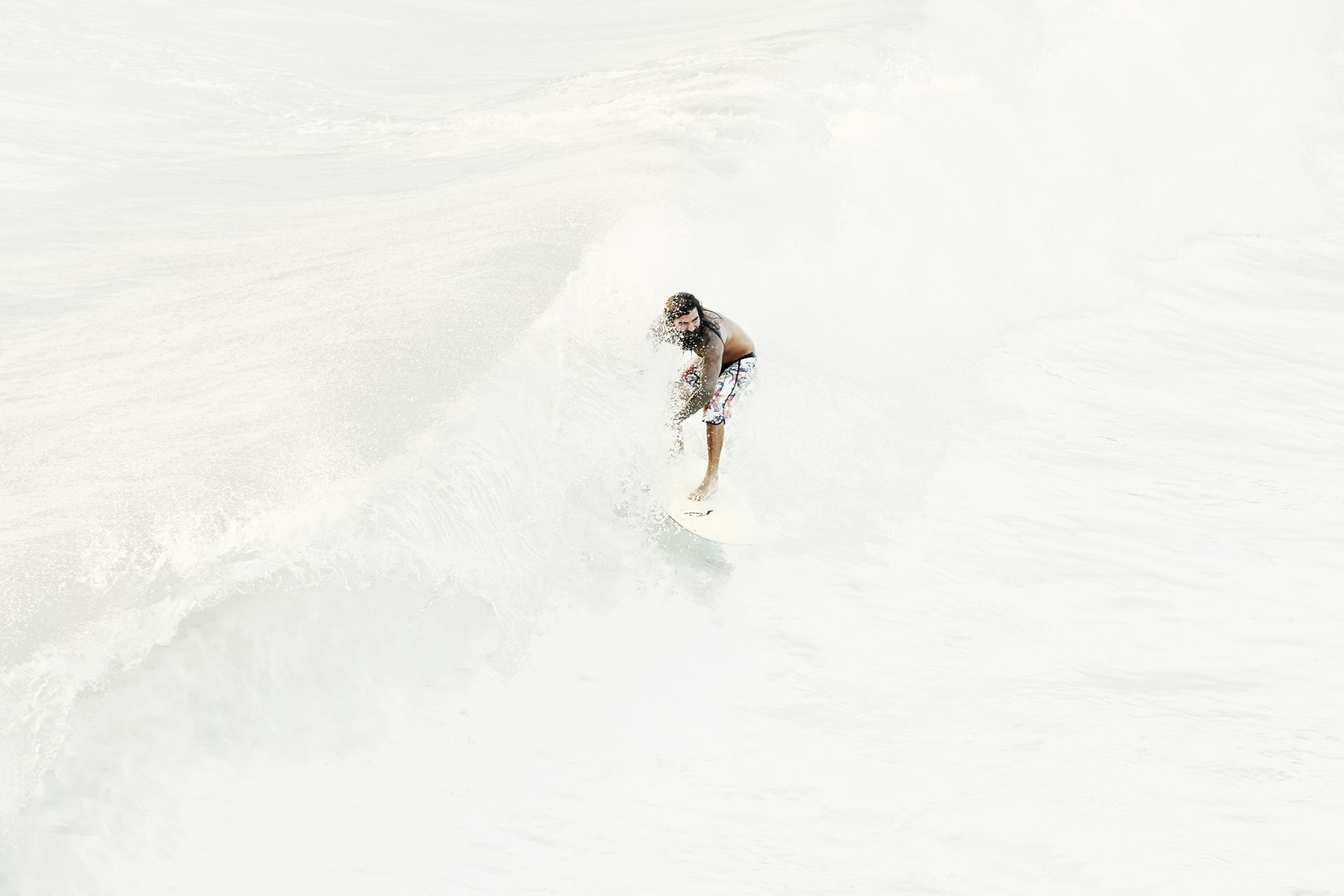 Surfer in a white sea surfing a wave.