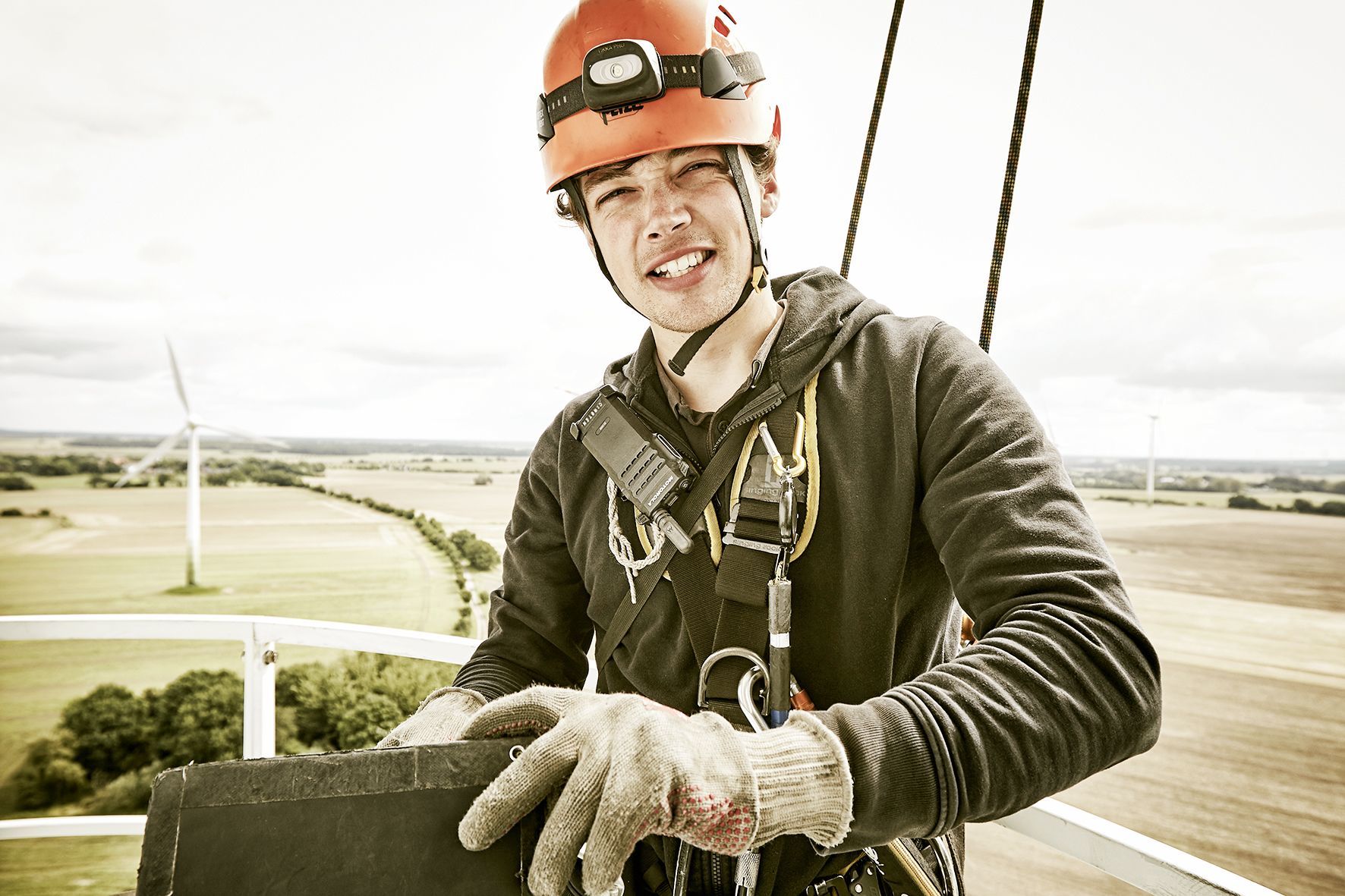 Portrait of industrial climber writting his protocol on top of a wind turbine on Fehmarn.