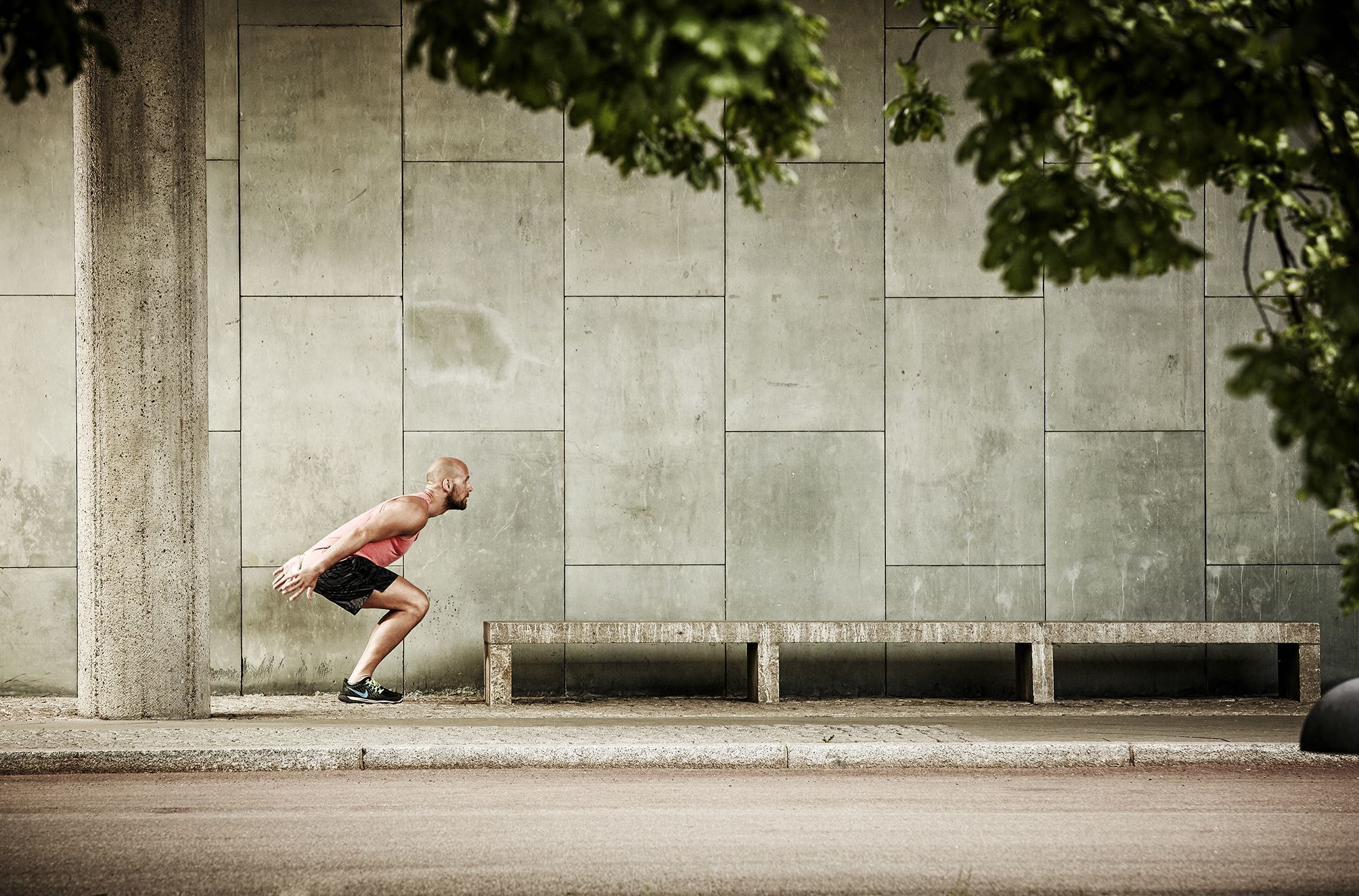 Fitness tainer getting ready to jump onto a bench