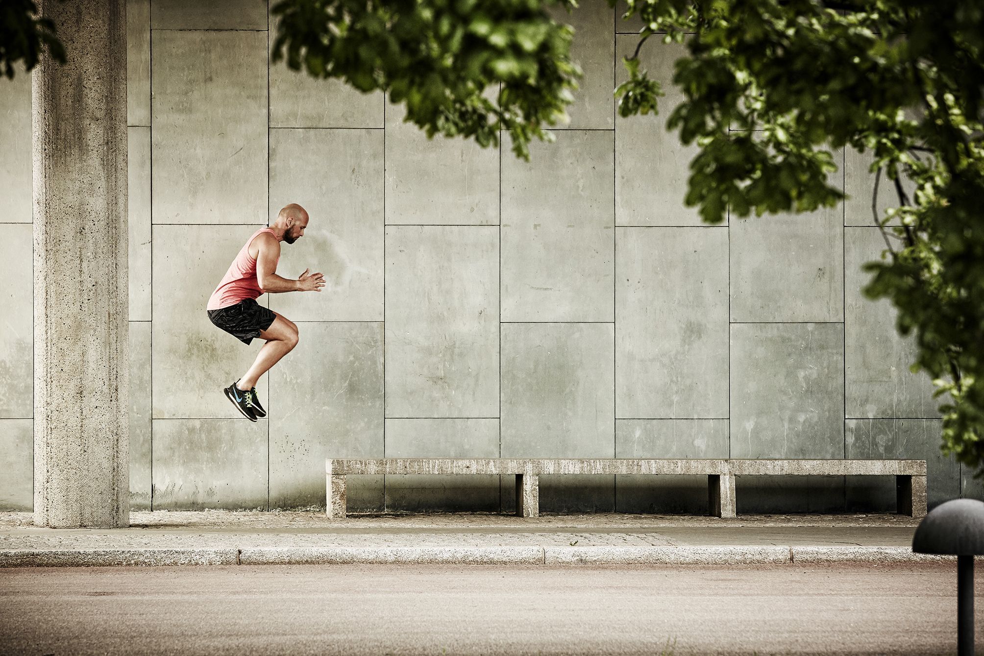 Fitness trainer jumping onto a bench