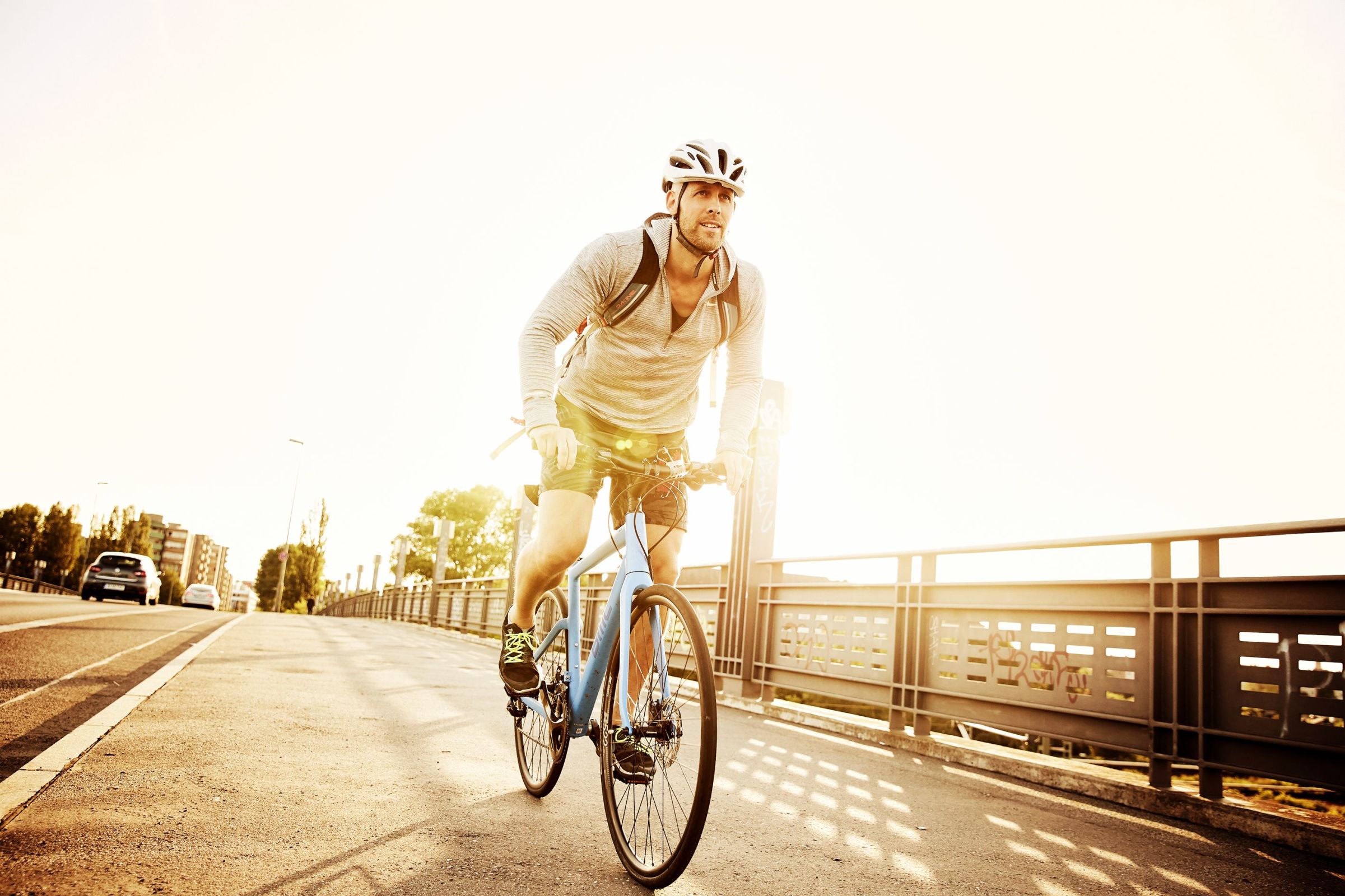 Personal trainer in Berlin riding his BMC street bike over a bridge at sunset.