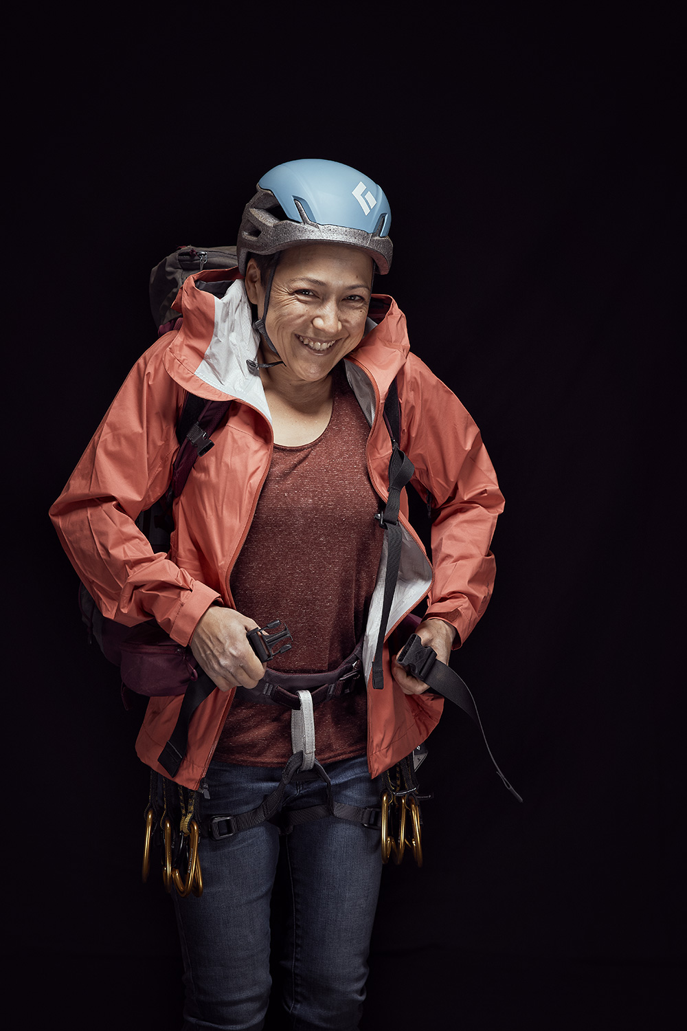 Rammountain athlete closing her backpack infront of a black background