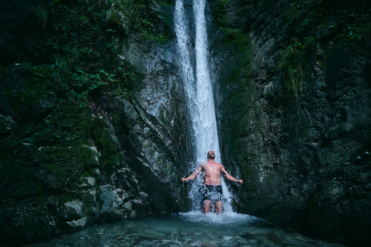 Man bathing under a freezing waterfall and screaming for joy