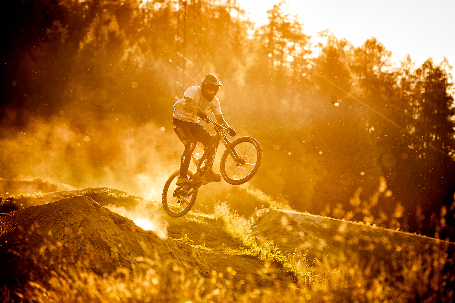 MTB athlete jumping in the sunset with dust flying at Innsbruck bike park