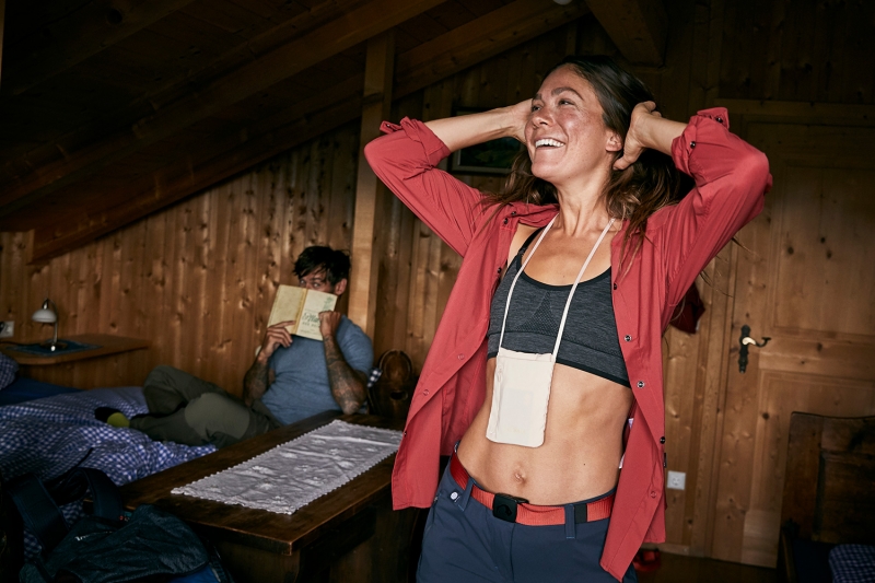 Girl getting undressed in a mountain hut while the boy behind her hides his face in a book