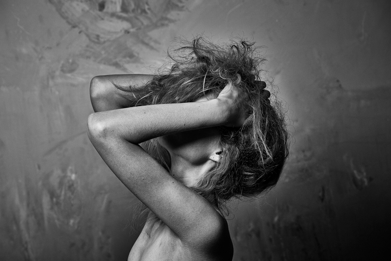 Black and white portrait of a girl hiding her face