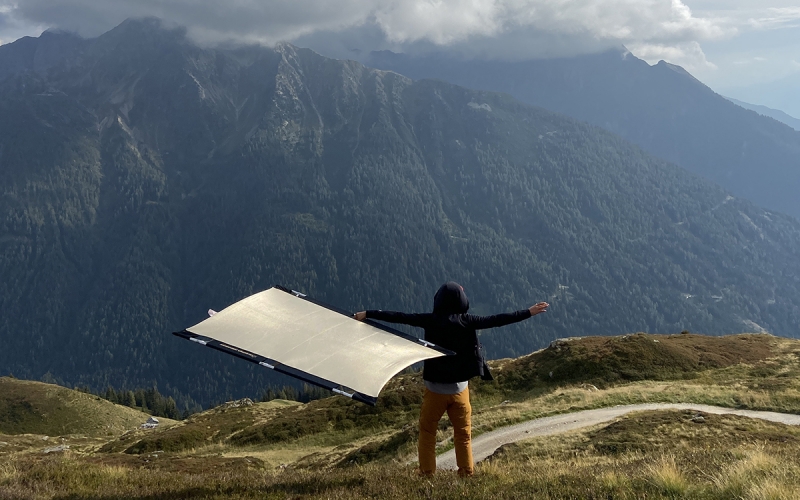 Jessica Zumpfe's assistant with sunbounce on a mountain in the dolomites for TATONKA