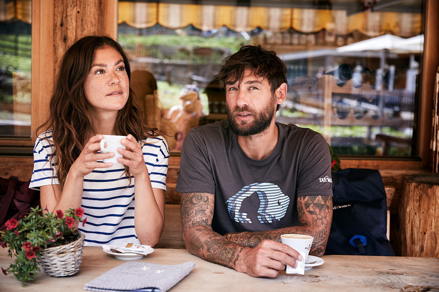 A couple having a coffee break from hiking at a mountain hut