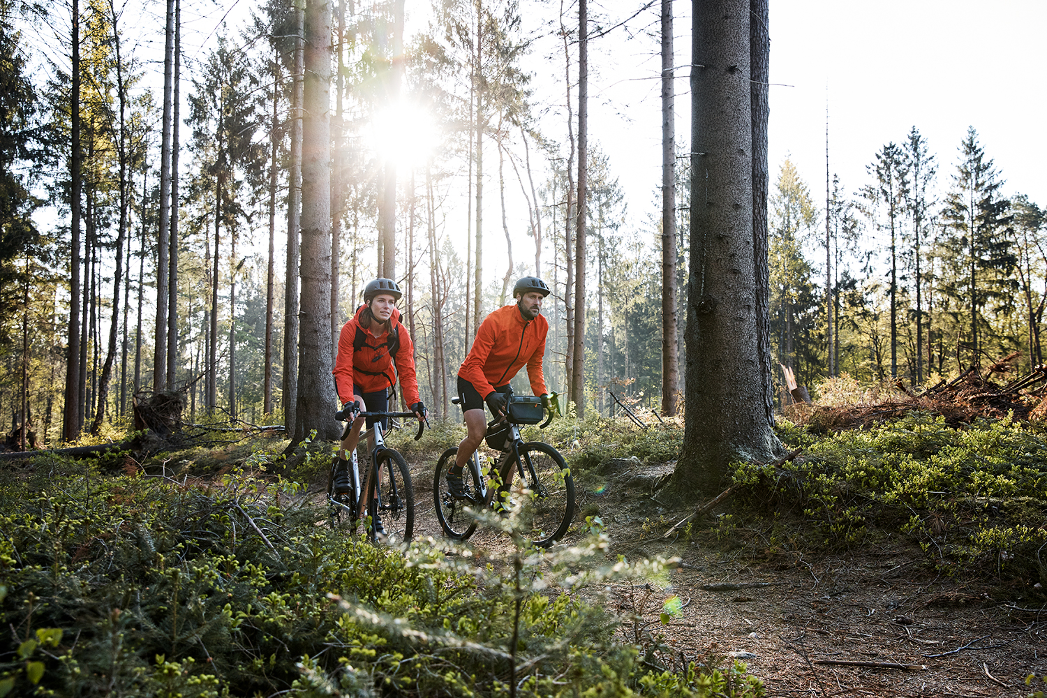 Couple riding their gravel bikes through the early morning woods