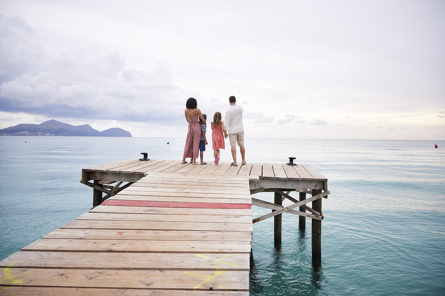 Family watching the sunrise on a jetty on Mallorca