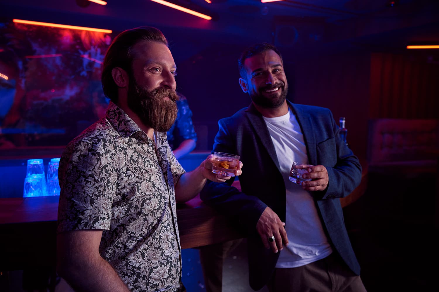 Two men standing at the bar drinking whiskey