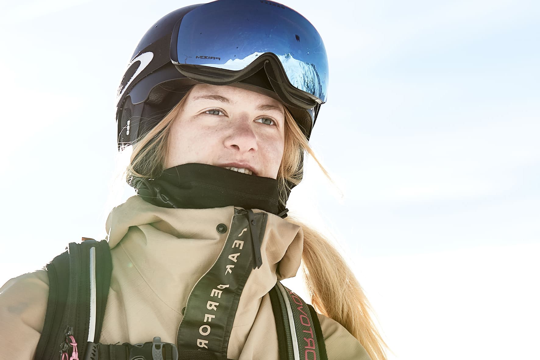 Portrait shot of a ski girl wearing a helmet and goggles while climbing the slopes on a ski tour.