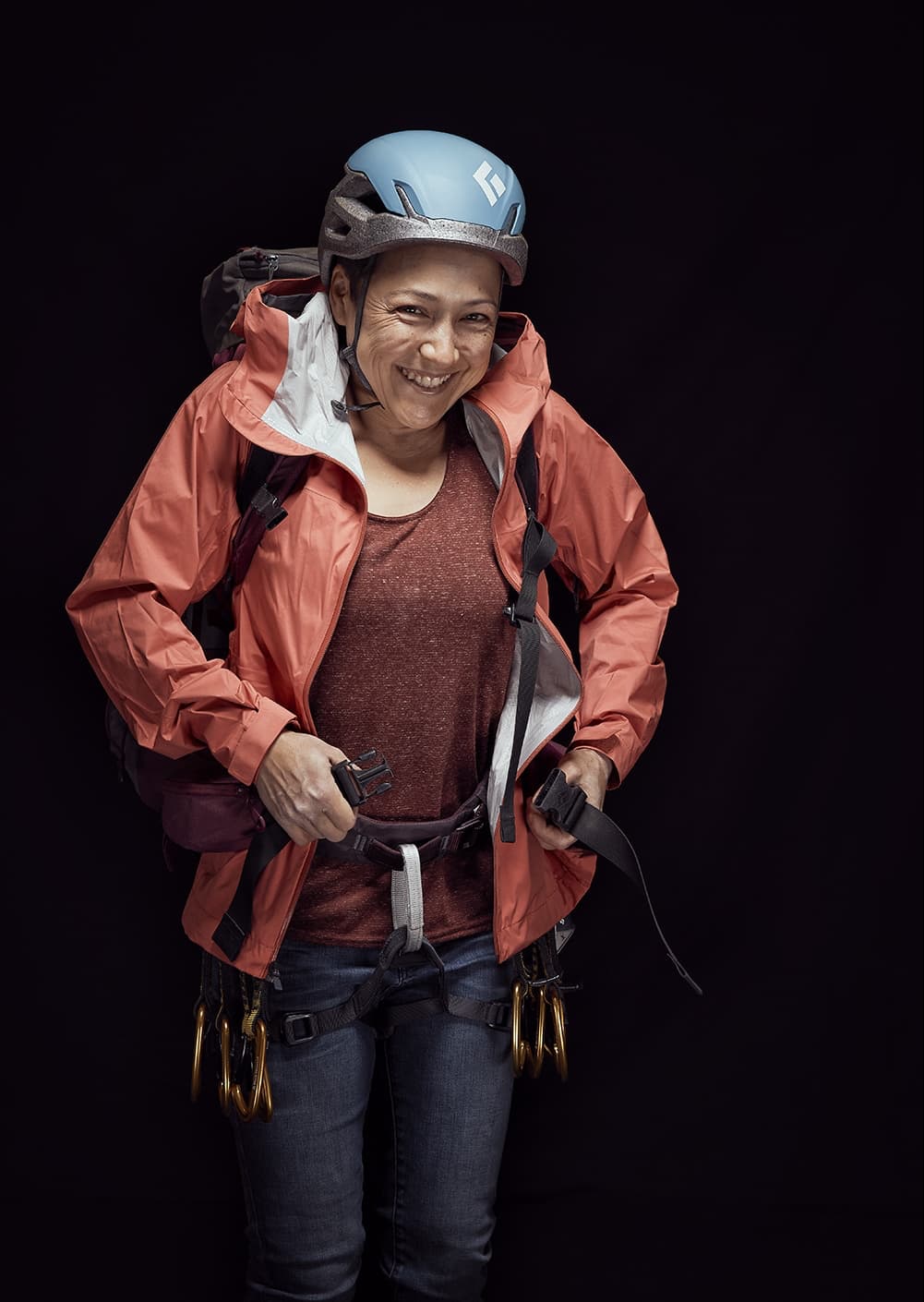 Rammountain athlete closing her backpack infront of a black background