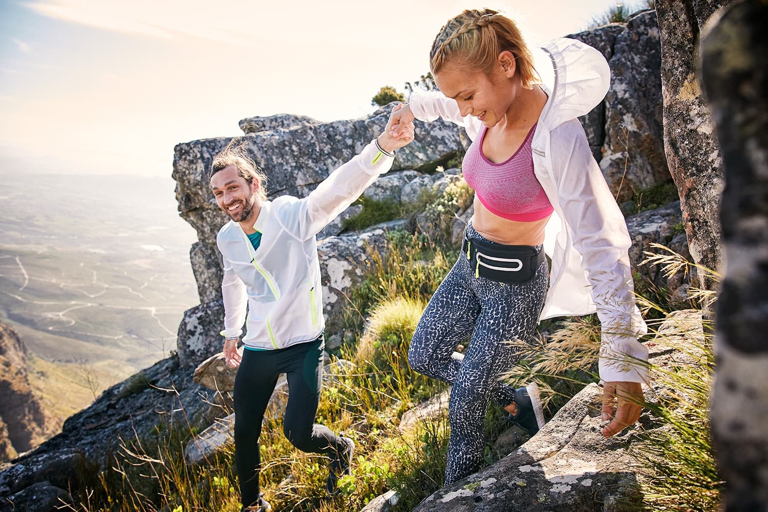 A Man and Woman scrambling over rocks at the du Tooitskloof mountain range.