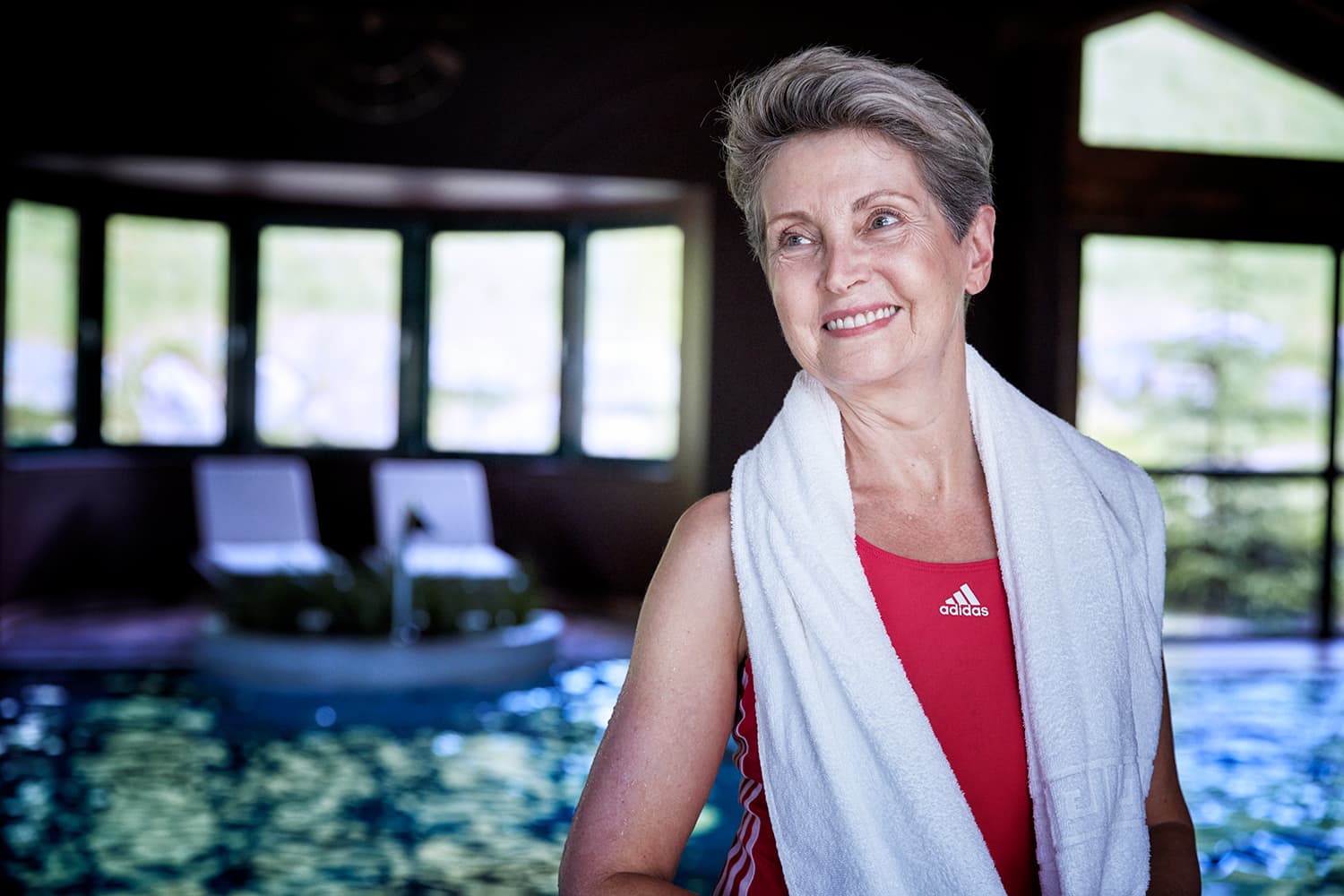 Grandmother standing in front of an indoor hotel pool in Kitzbuehl