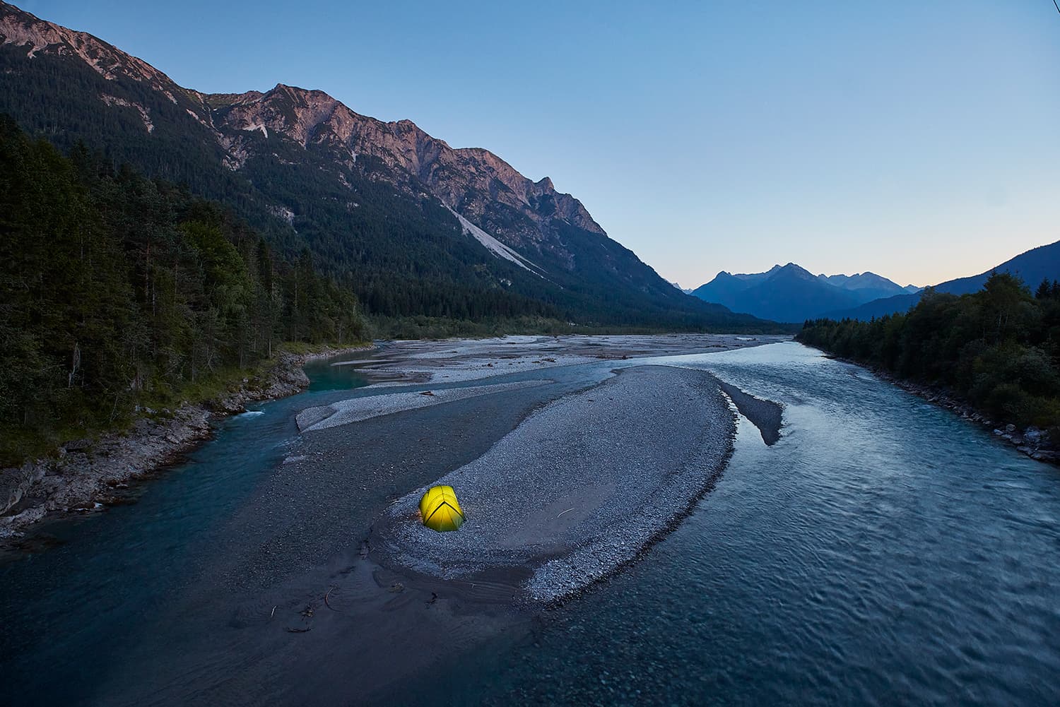 Tent on an island in the river after sunset