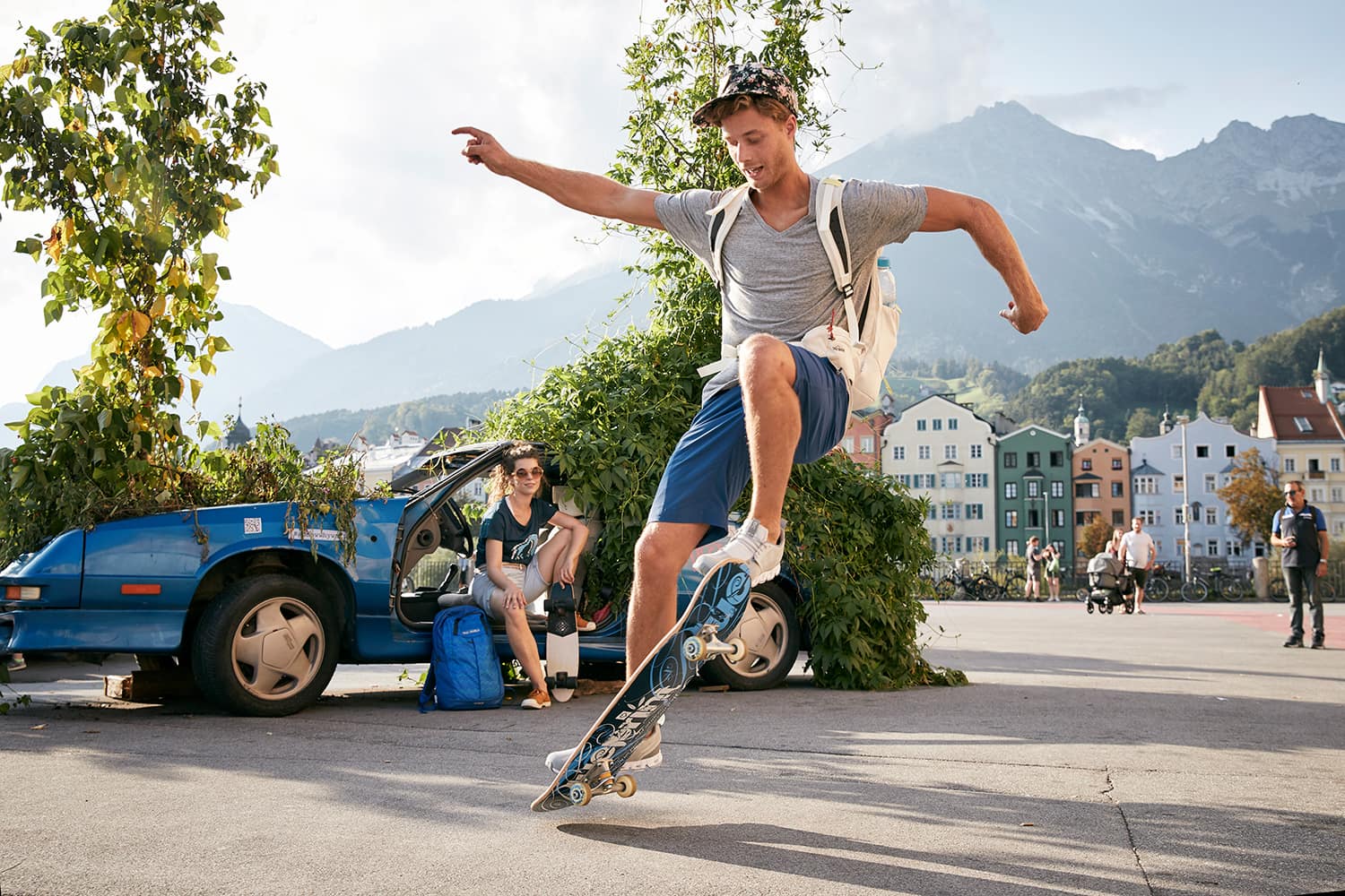 Boy doing skateboard tricks infront of his girlfriend in a plant car on the marketplace of Innsbruck