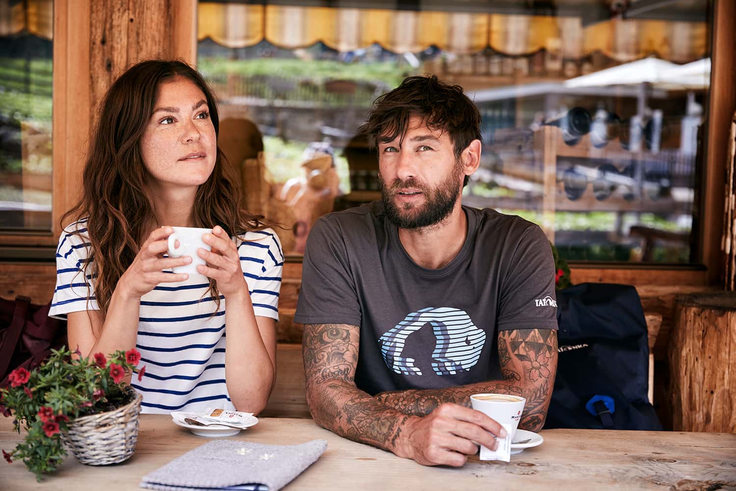 A couple having a coffee break from hiking at a mountain hut